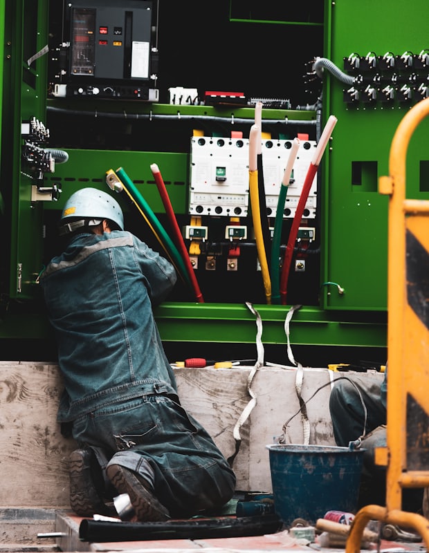 Técnico operativo de campo trabajando en un tablero eléctrico